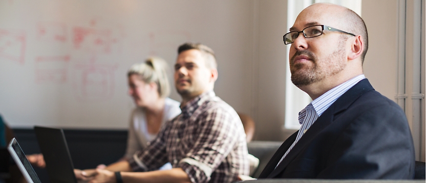 A group of people sitting in a conference room.