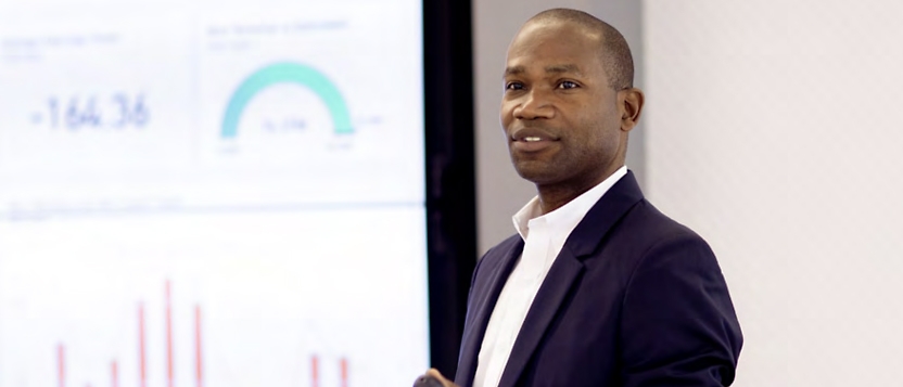 A man giving a presentation in front of a screen.