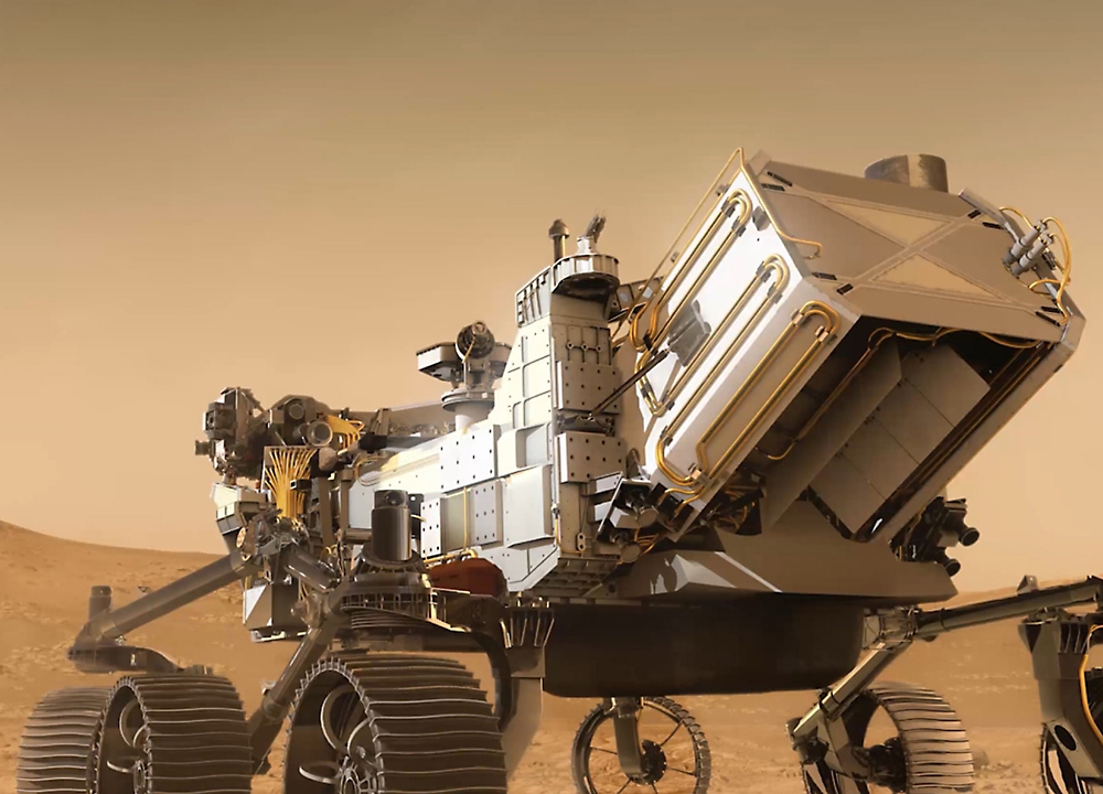 Een gedetailleerd model van een Mars-rover met zes wieltjes en complexe wetenschappelijke instrumenten die zich op een gesimuleerd Mars-oppervlak bevinden.