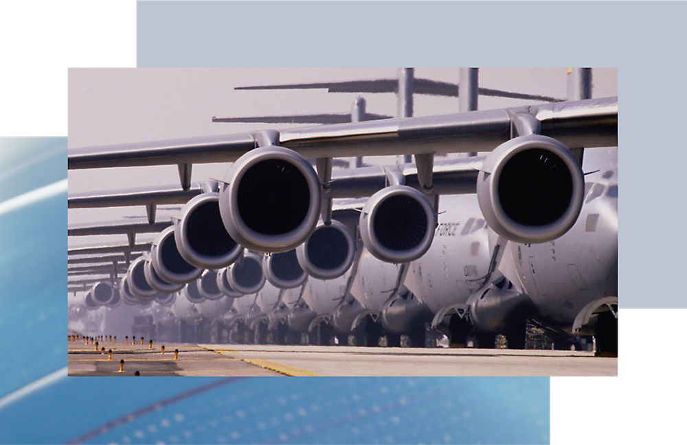 一排大型飞机发动机排列在停机坪上，在清晰的蓝天背景下展示它们的正面。