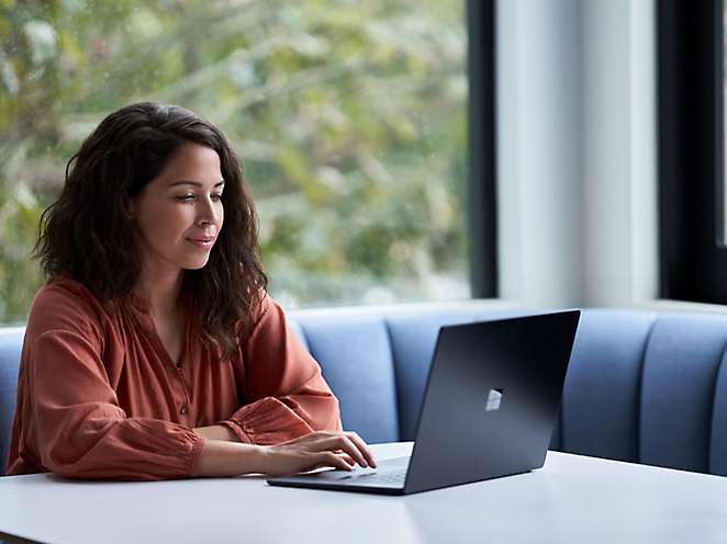 A person sitting at a table using a computer