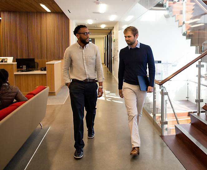 Two men walking down a hallway