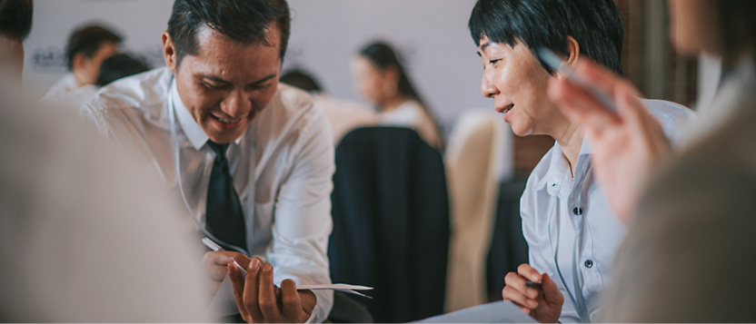 Business professionals discussing documents at a table during a meeting.