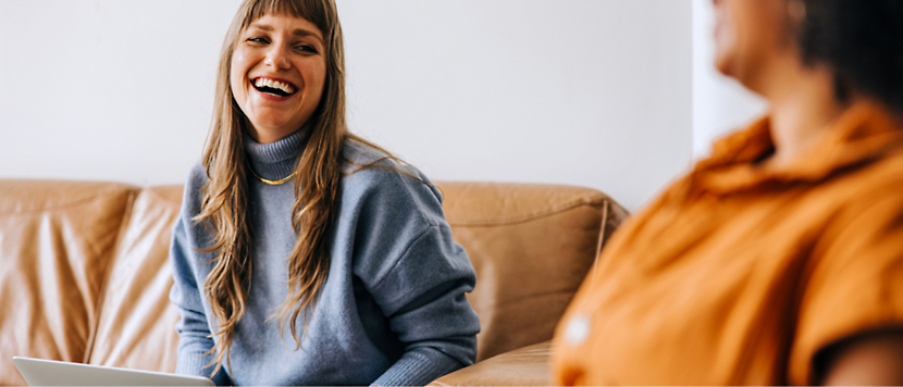 A person laughing on a couch