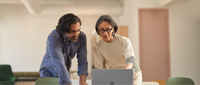 A person and another person looking at a computer