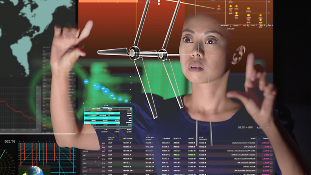 A person pointing at a large screen with graphs