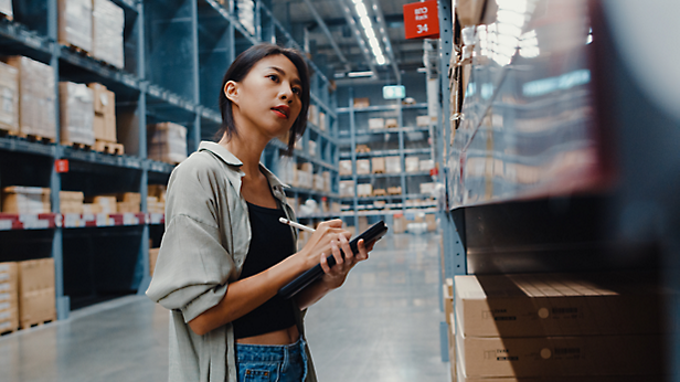 A girl standing and taking details of products in a store.