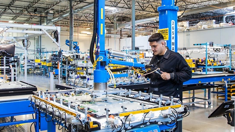 A factory setting with an employee working on a machine.