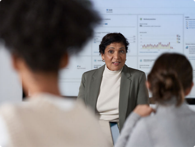 A person in a suit speaking to a group of people