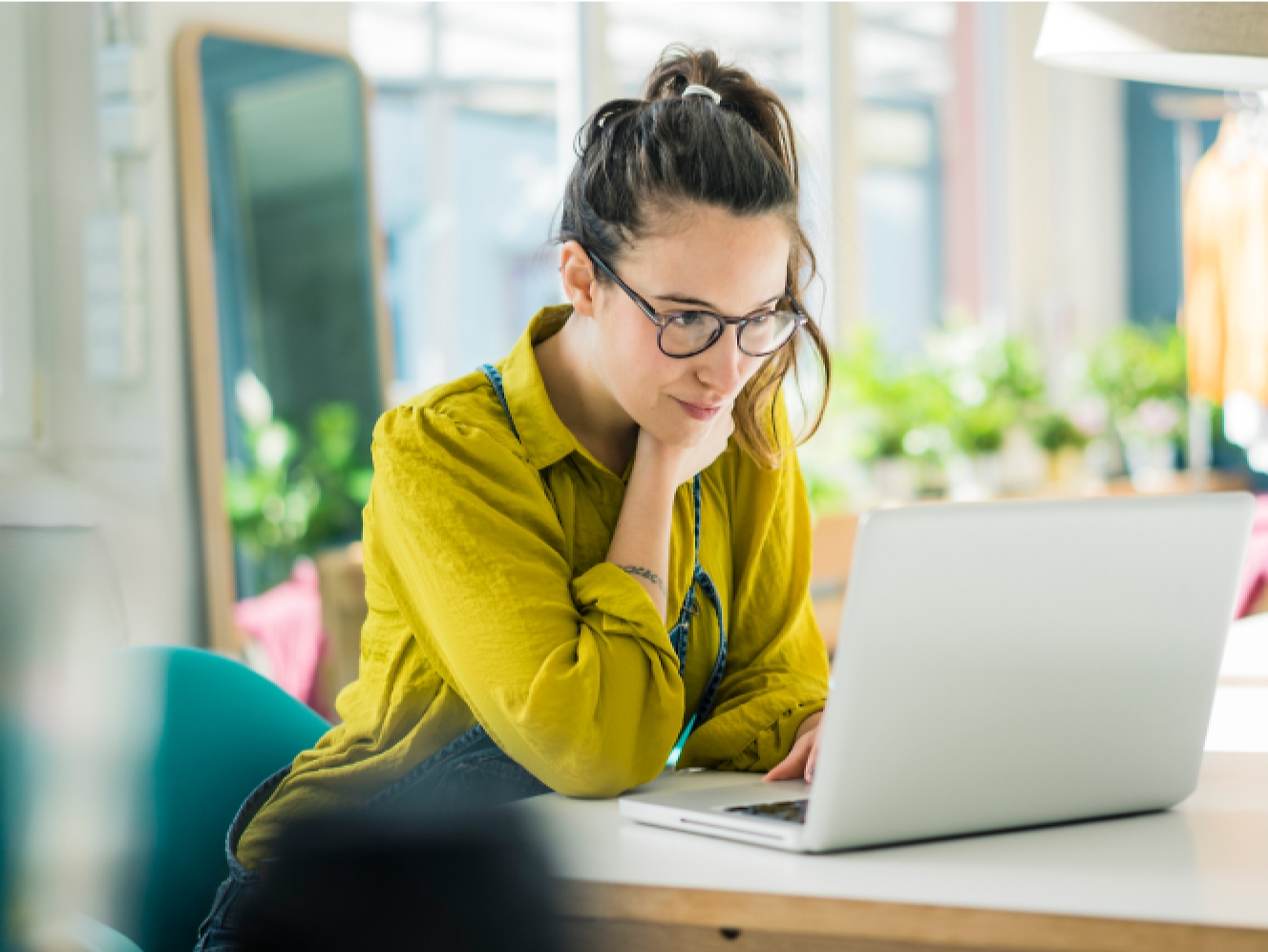 A woman working on a laptop in an office.