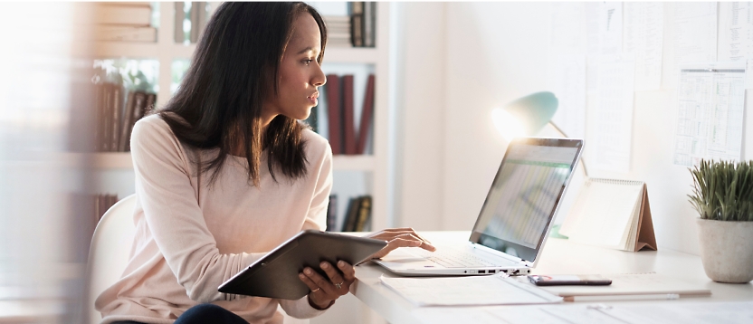 Een vrouw die aan een bureau zit met een laptop.