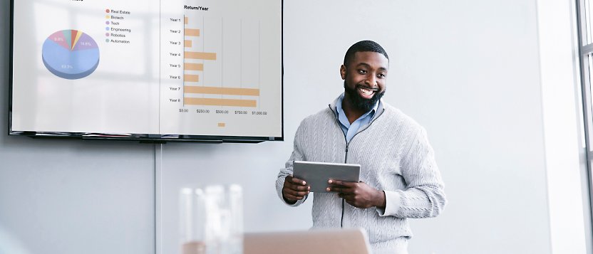 A man standing in front of a tv with a tablet in front of it.