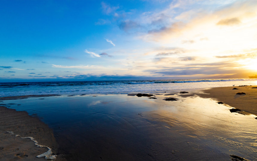 View of the ocean shore at sunrise.