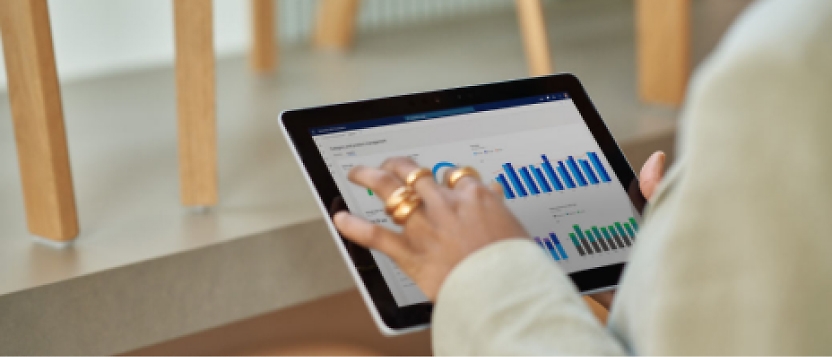 A woman is using a tablet with a graph on it.