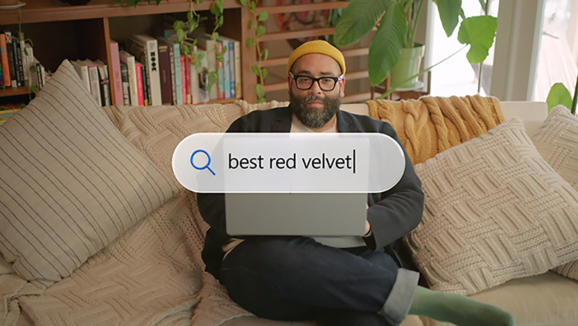 A man sitting on a couch with his computer on his lap