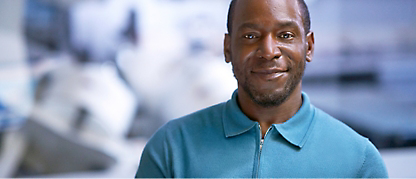 A man smiling in a blue shirt