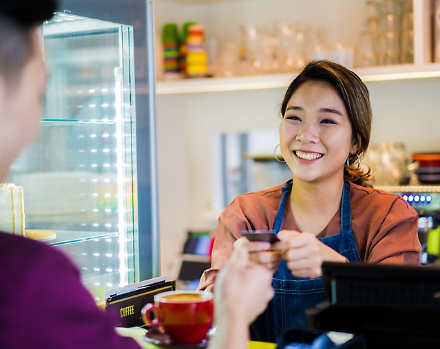 A man is taking his card back from salesgirl.