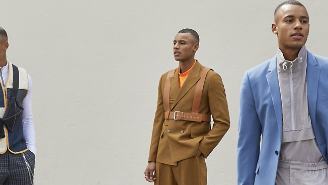 A man in a tan suit is standing next to a man in a blue suit.