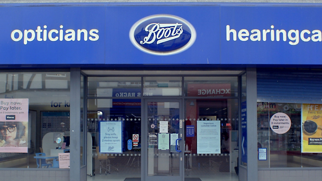 Forsiden av en Boots-butikk med et blått skilt.