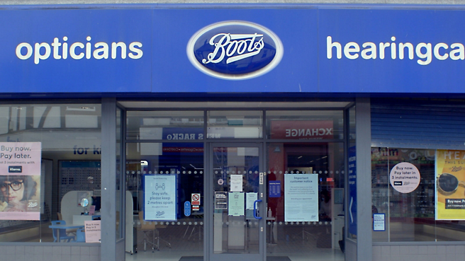 El escaparate de una tienda de botas con un signo azul.