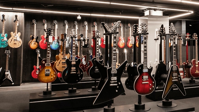 Many guitars are on display in a store.