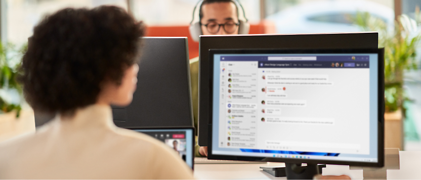 A person using multiple monitors and working in her office