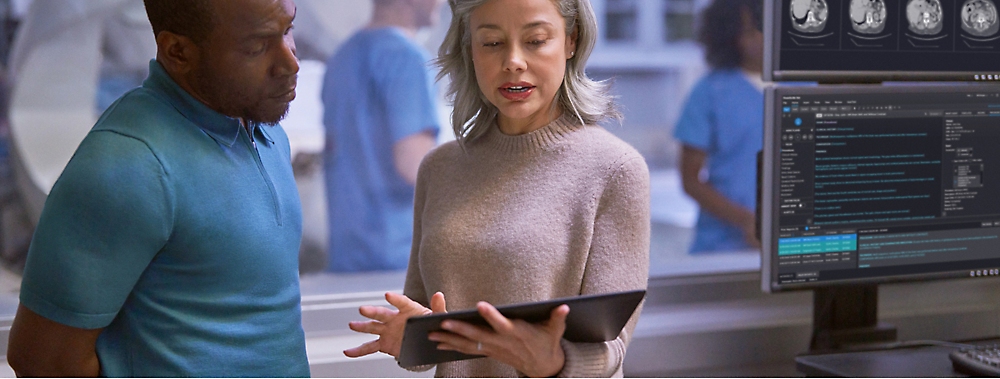 A person holding a tablet and talking with another person