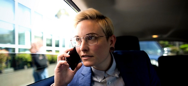 Femme en lunettes qui parle sur un téléphone portable.