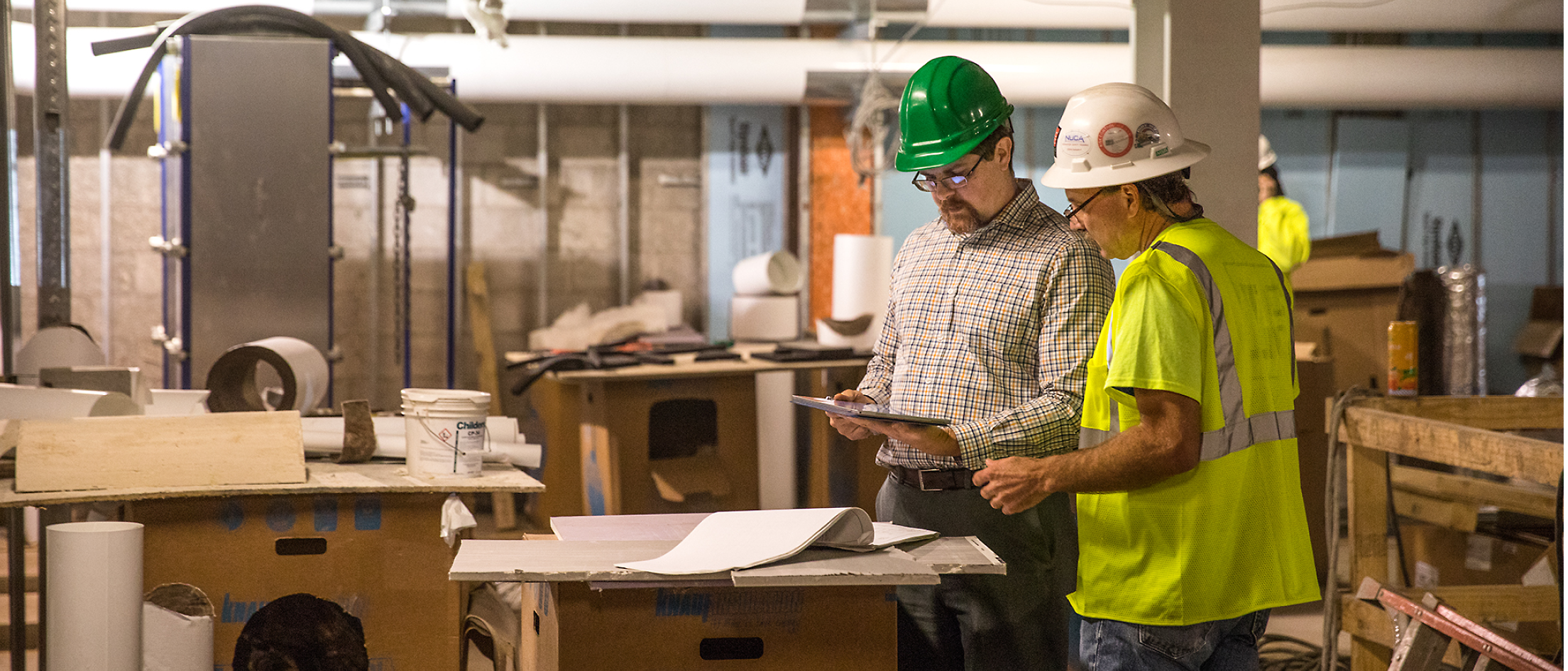 A group of men in hardhats looking at a tablet