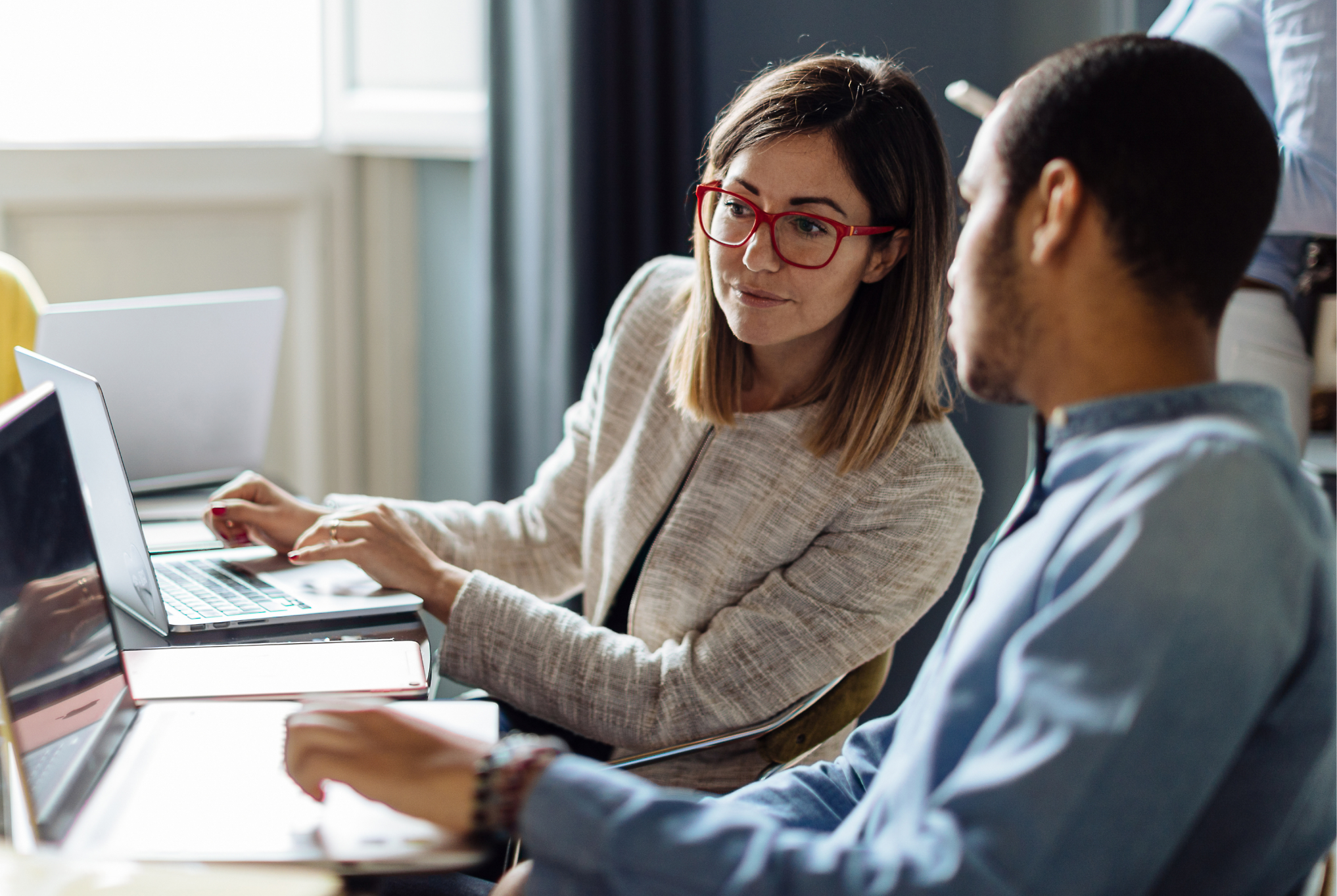 A person and another person looking at a computer