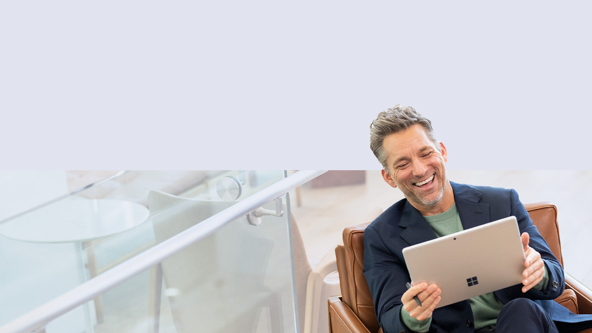 Sohvalla istuva mies pitää Surface Slim Pen 2 -kynää kädessään nauttiessaan Surface Pro 9 -laitteestaan