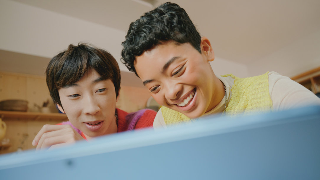 A couple sitting looking at a Surface device together