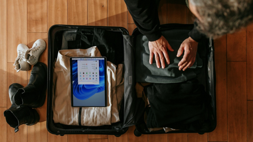 A digital nomad packs his Surface device in his suitcase