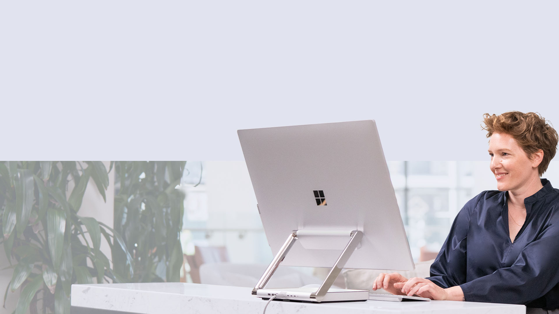 A person types at their Surface Studio 2+