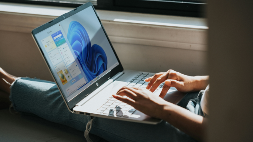 A person using a Windows 11 laptop on their lap