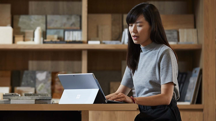 Eine Person arbeitet in einem Bürobereich mit einem Surface-Gerät