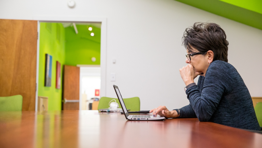 A person sitting at a table with a computer