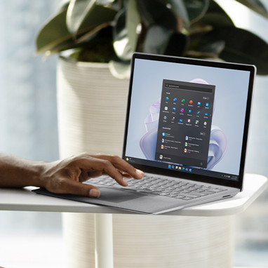 A person’s finger is observed touching the screen of a Surface Laptop 5