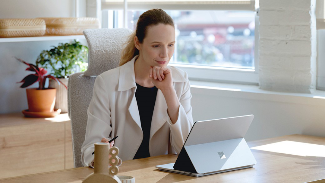 Una mujer sostiene un Surface Pro y habla con otra en el escritorio de un recepcionista