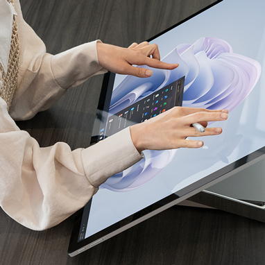 Nainen on vuorovaikutuksessa Surface Studio 2+ -laitteen näytön kanssa