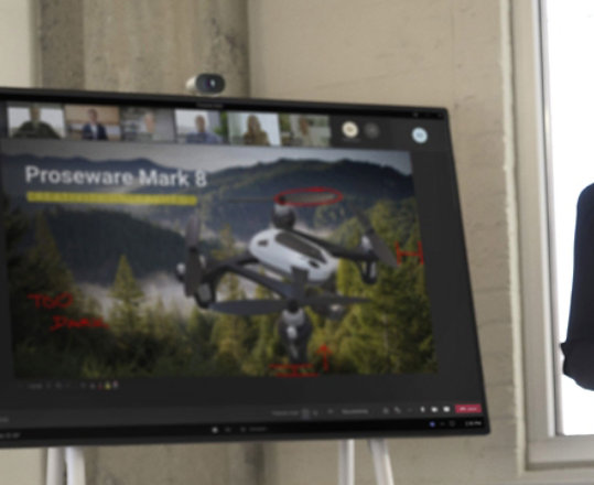 Kobieta stoi przed urządzeniem Surface Hub podczas prezentacji dokumentu PowerPoint w wideorozmowie Teams