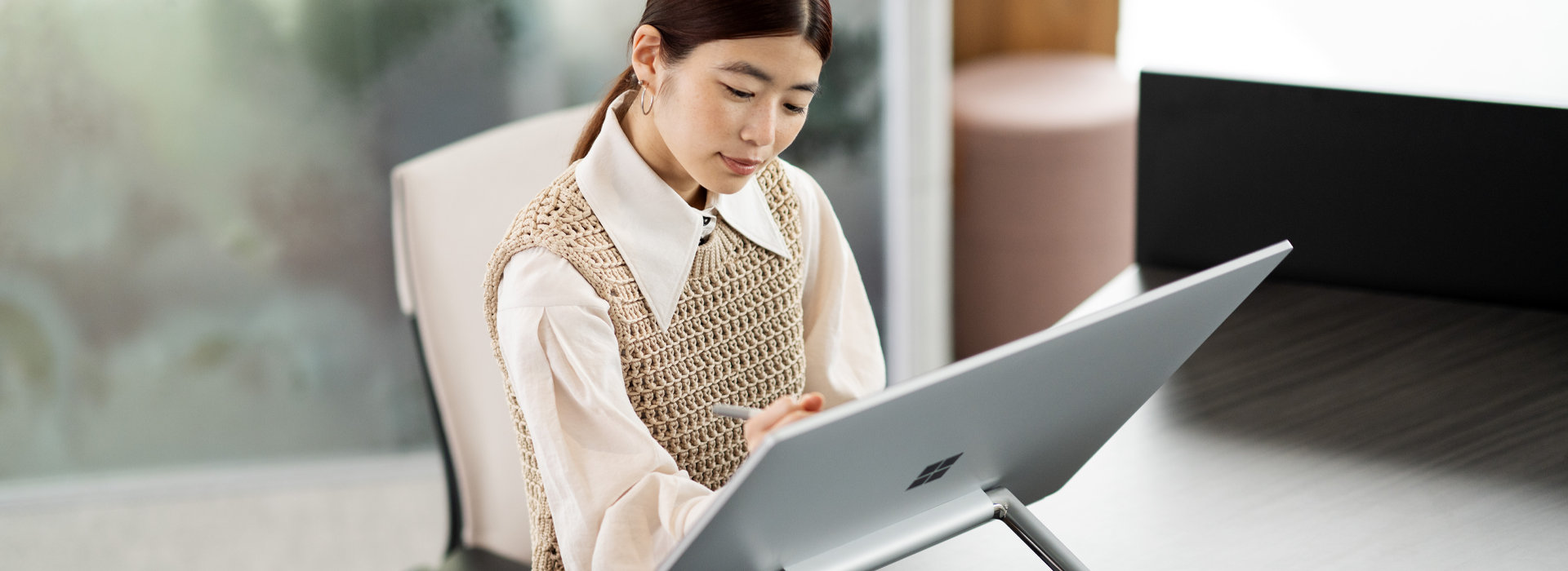 Una mujer trabaja con Surface Studio 2 Plus en su oficina doméstica.