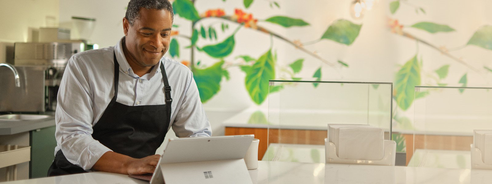 Un hombre que trabaja con un Surface Pro 7+ en su restaurante