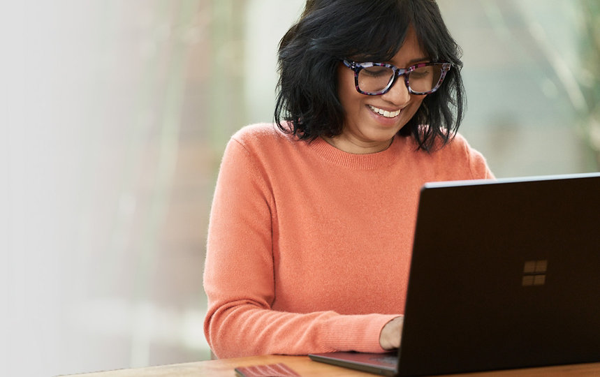 Person smiling and working on a laptop