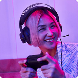 Person med kort hår har på hodetelefoner og holder en spillkontroller