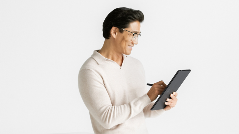 Man sitting and holding Surface Pro 10 in tablet mode