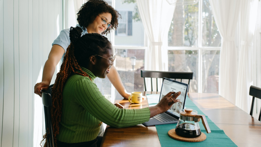 Two women use Microsoft Surface to browse the Internet in a dining room