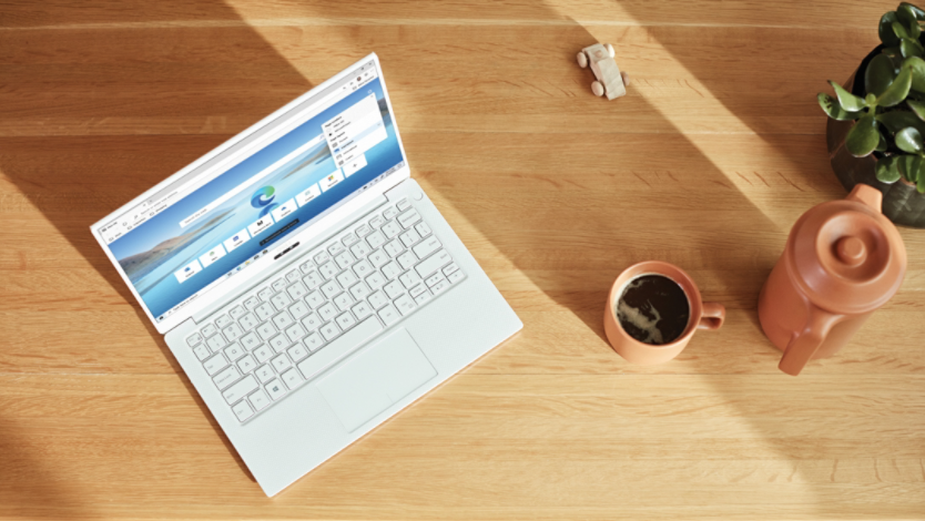 White laptop sitting on a wooden table with Microsoft Edge open