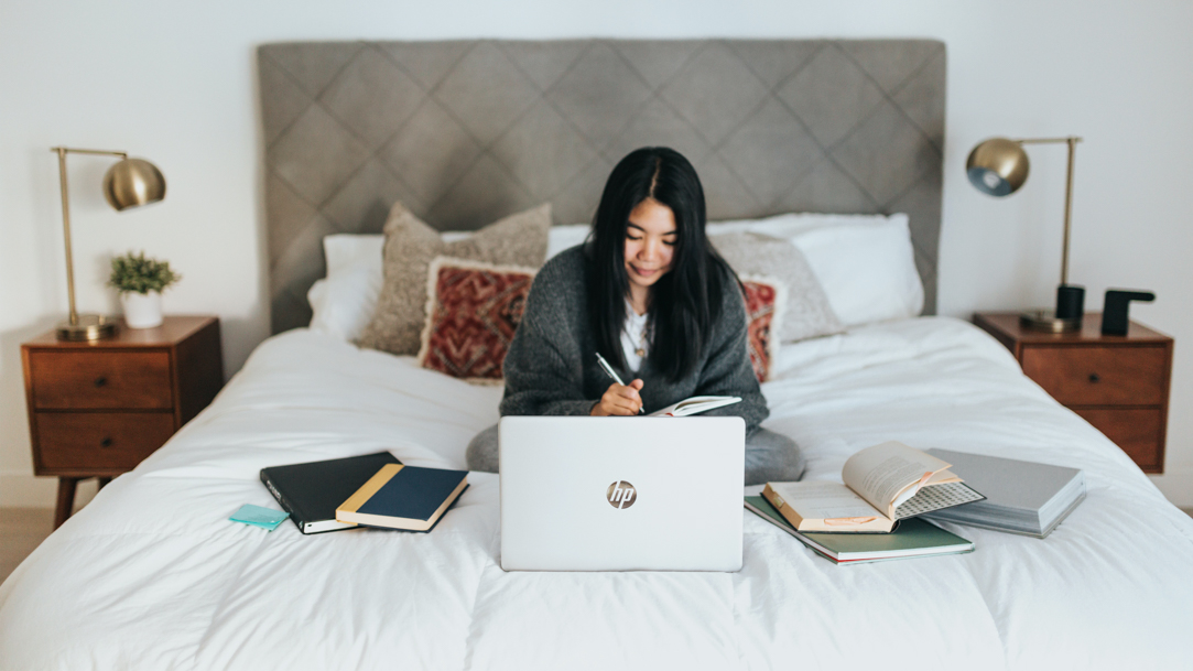 Woman using a laptop in bed