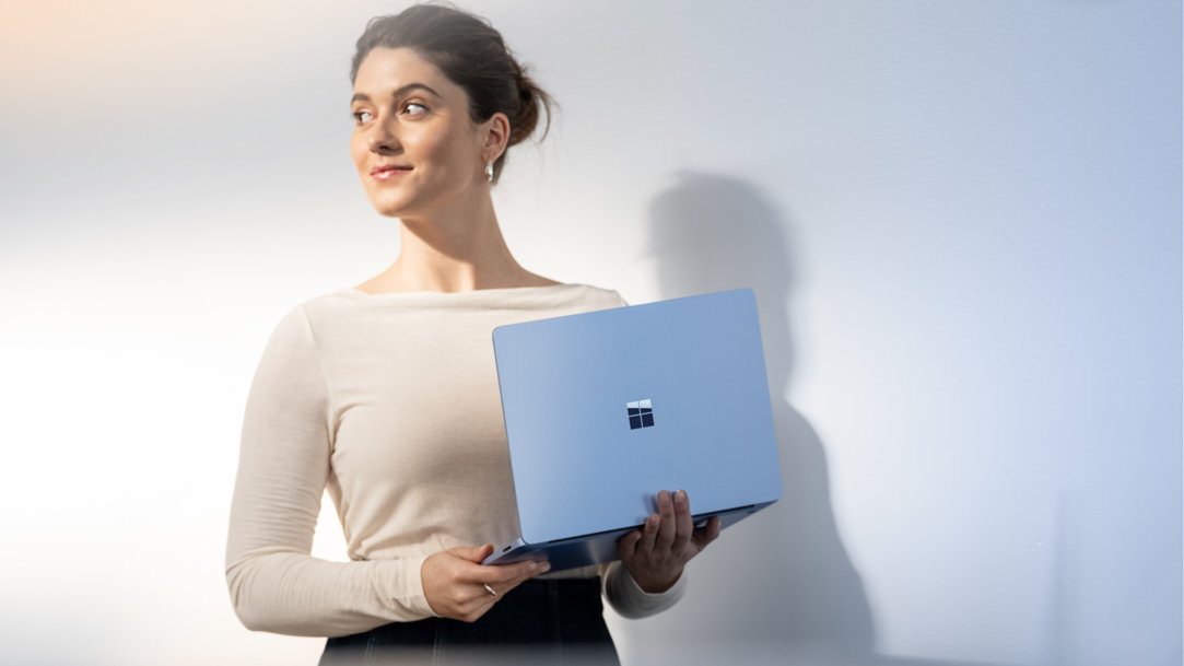 Woman holding Surface Laptop 7ᵗʰ Edition